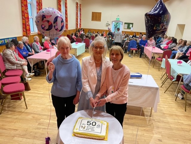 Former leaders Noreen West, Ruth Emerson and Dorothy Woods cut the Brownie birthday cake.