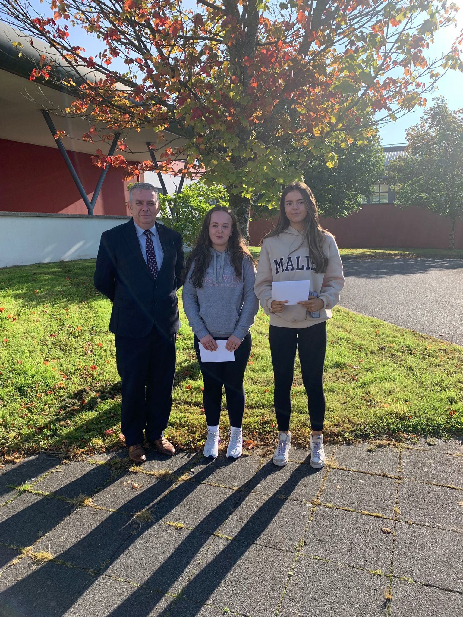 St. Fancheas College Principal Maurice Collins congratulates Molly Carron and Lara Beckett. 